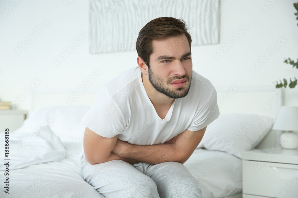 Handsome man feeling stomach pain at home Handsome man feeling stomach pain at home