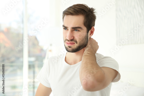 Handsome man feeling neck p...