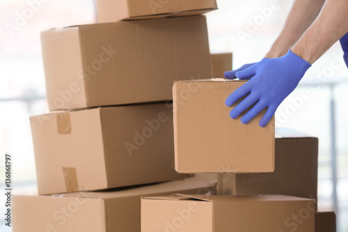 Delivery man moving boxes indoors