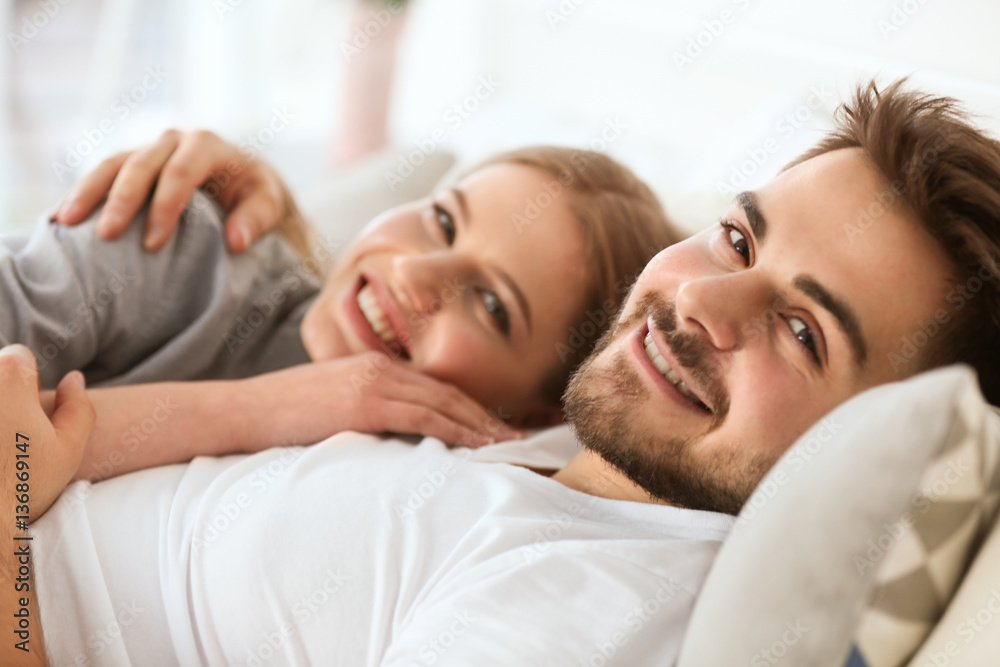 Cute young couple lying on bed at home Cute young couple lying on bed at home