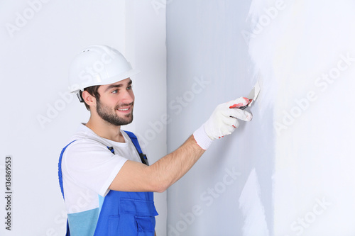 Young worker making repair in room photo