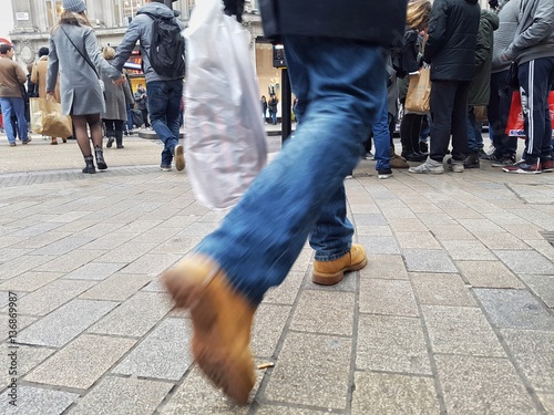Men rushing in the sidewalk in a busy street during peak hours