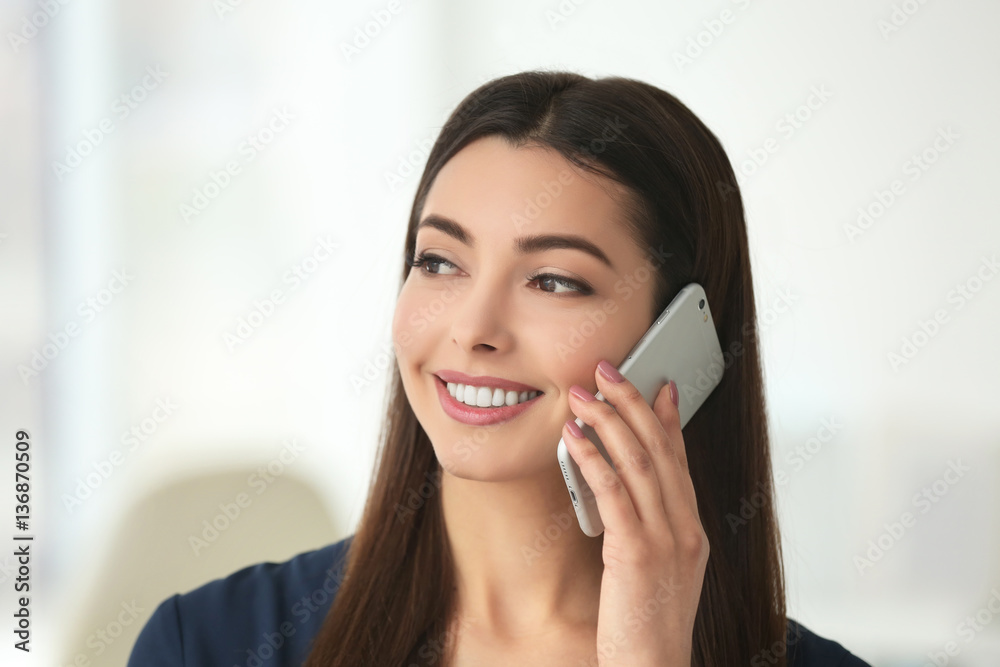 Beautiful young woman talking by mobile phone indoors Beautiful young woman talking by mobile phone indoors