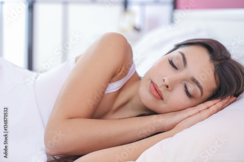 Beautiful young woman sleeping in bed at home