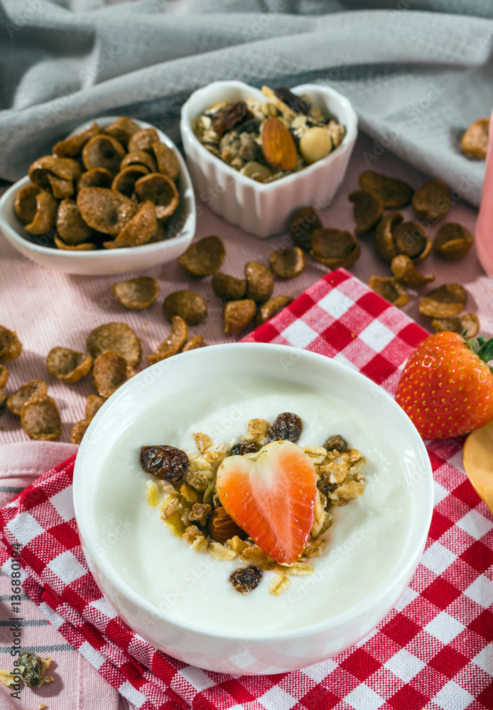 Breakfast set. Strawberry fruit over the yogurt in white bowl wi Breakfast set. Strawberry fruit over the yogurt in white bowl wi