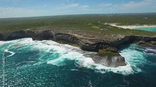 Flight along rugged ocean coastline with breaking waves on bright sunny day.  Kangaroo Island, South Australia