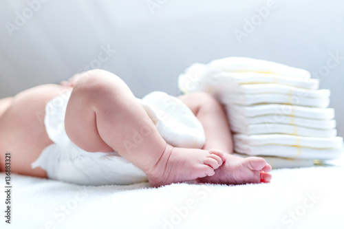 Feet of newborn baby on changing table with diapers Poster Mural XXL