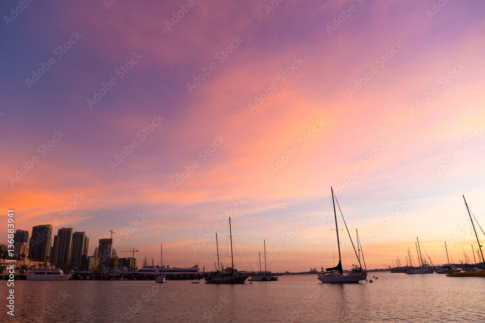 Pink, yellow, red, orange sunset sky in California, San Diego. Sailboats, boats. Silhouette