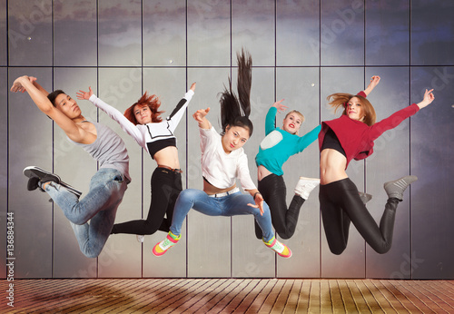 Modern dancing group practice dancing in front wall