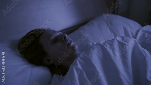 Restless dreams of sleeping woman interrupted by waking up for nightmares