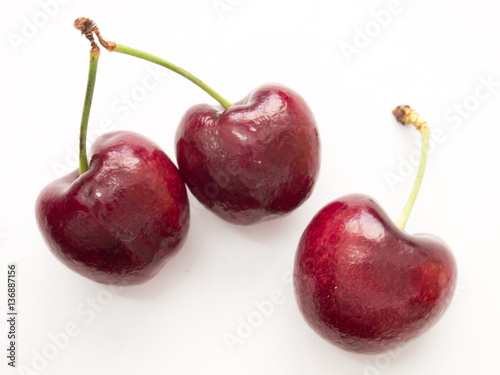 Three red cherry on white background