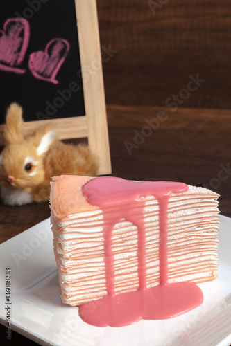 Obraz na płótnie Pink crepe cake with pink custard sauce on wooden table w salonie