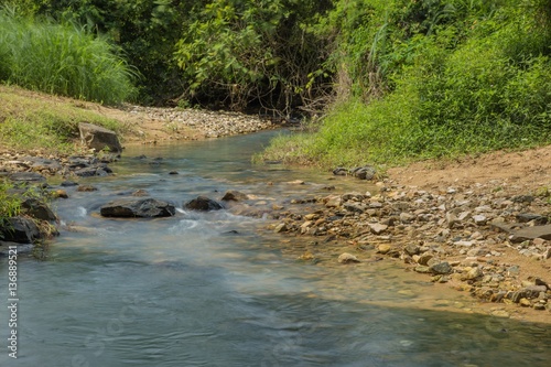 Rocky little stream with lush green vegetation in tropical Vietnam. © Paul Hampton