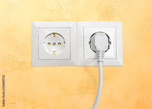 Two white socket outlet with one connected corresponding power plug