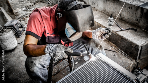 Closeup of man wearing mask Welding steel structures and bright sparks in a workshop