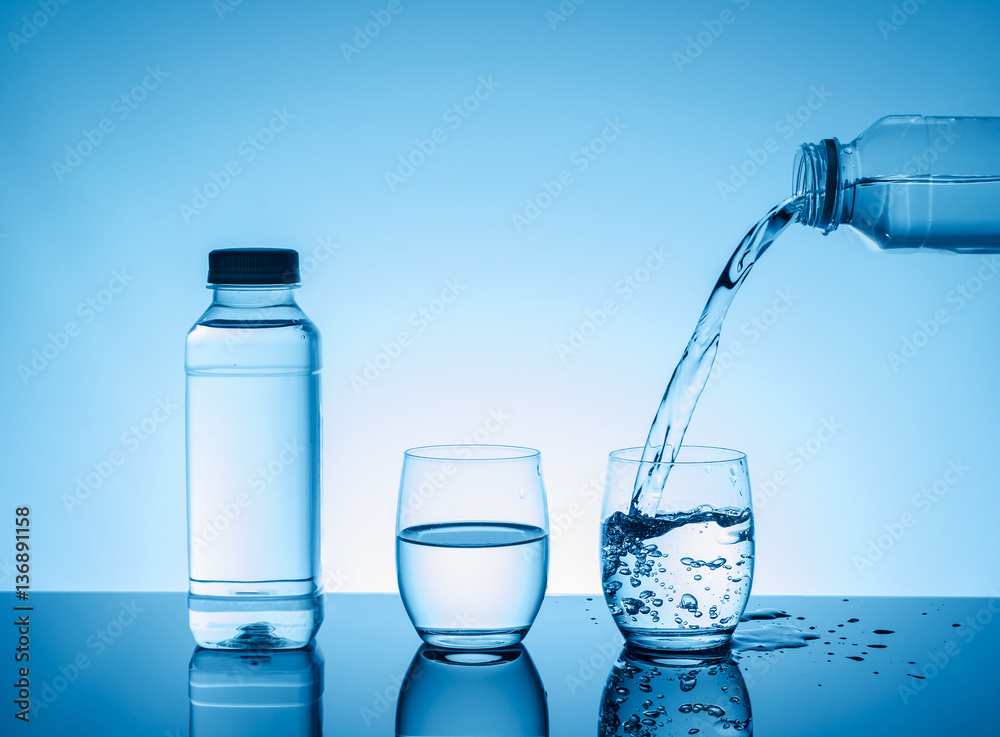 Bottle with creative splashing water in the glass Bottle with creative splashing water in the glass