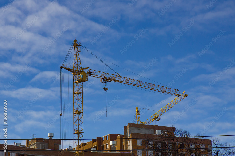 Crane and building construction site against blue sky Crane and building construction site against blue sky