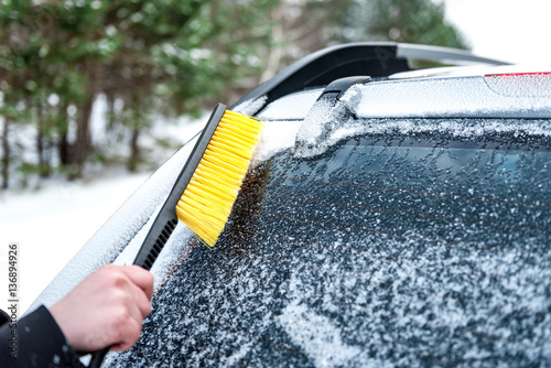Woman cleaning car windshield of snow winter happy young scraper