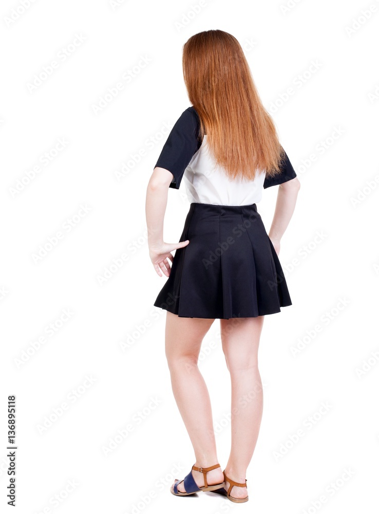 Back view of young redhead woman pointing at wall. Back view of young redhead woman pointing at wall.
