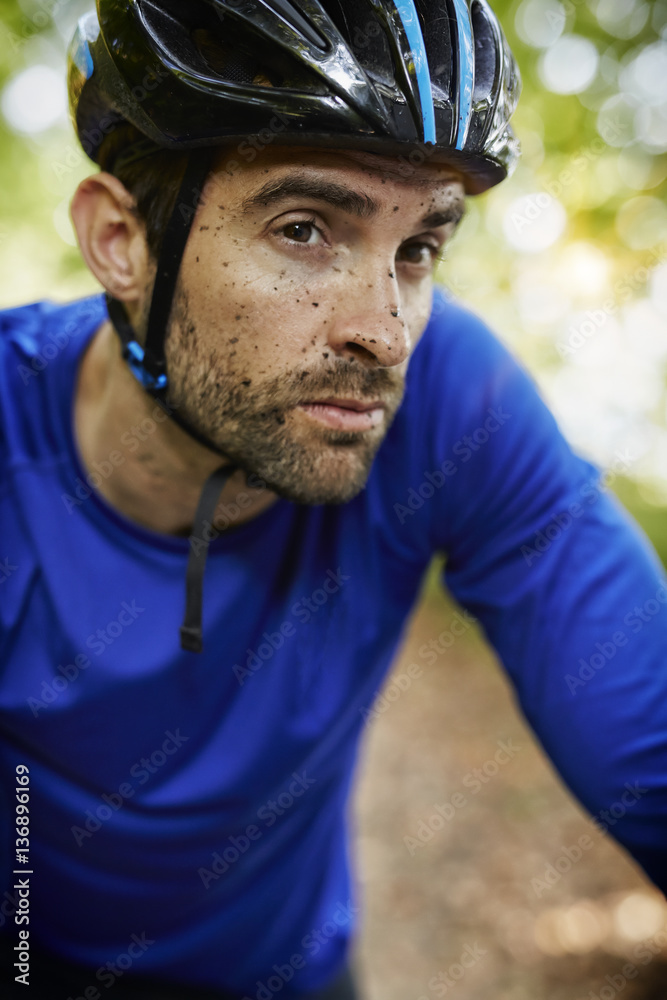 Fototapeta premium Muddy cycle man looking away, close up