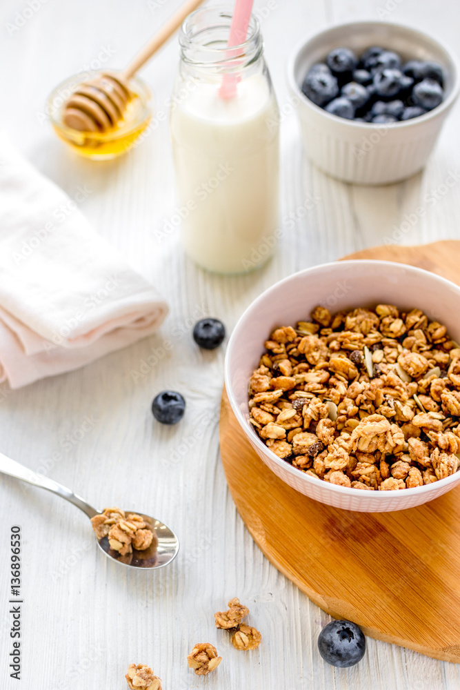 Fitness breakfast with granola, milk and honey on white background Fitness breakfast with granola, milk and honey on white background