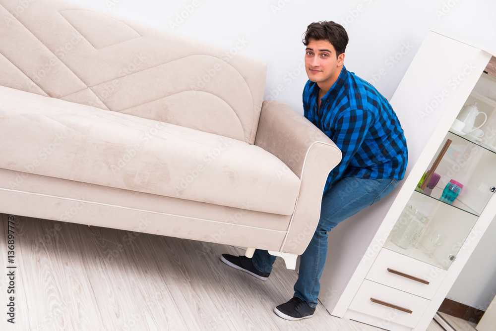 Young man moving sofa couch foto de Stock | Adobe Stock