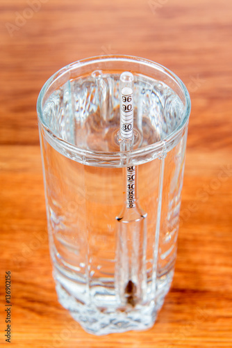 Full glass of vodka with alcoholmeters in close-up. Rules of measurement of alcoholic beverages fortress. Alcohol addiction.