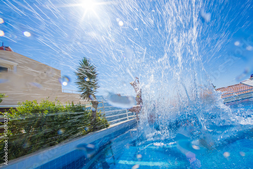 Man jumping in the pool with splashes