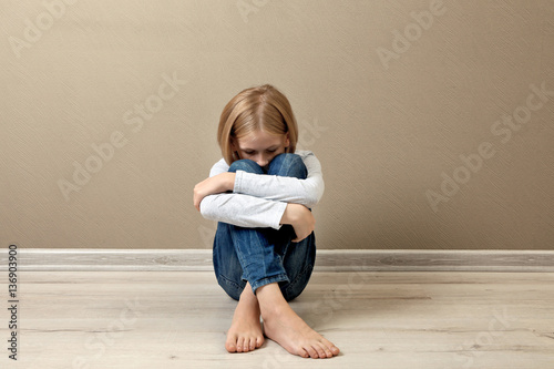 Upset girl sitting on the f...