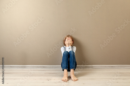 Upset girl sitting on the f...
