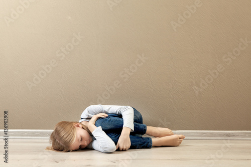 Upset girl lying on the floor at home
