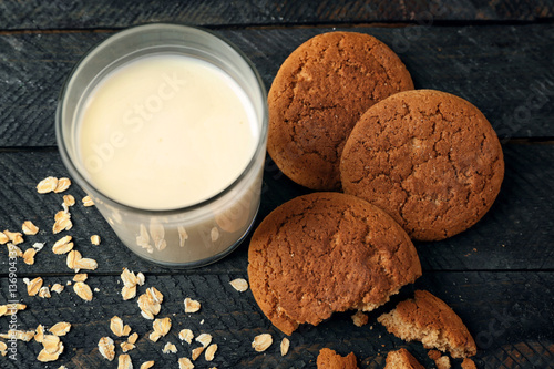 Oatmeal cookies with milk on wooden background
