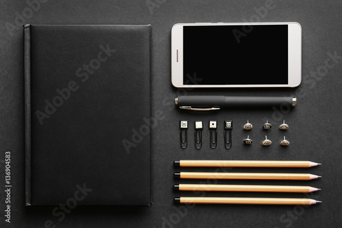 Flat lay of stationery and smart phone on black background © Africa Studio