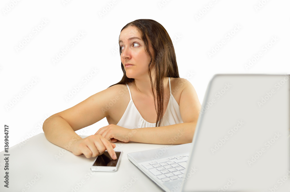 Lazy female employee playing games with her smartphone sitting in a desktop isolated on white background Lazy female employee playing games with her smartphone sitting in a desktop isolated on white background