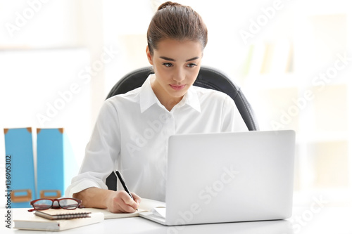 Beautiful young woman working in office