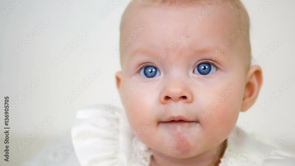 baby girl in white dress and headband sitting on the wooden floor baby girl in white dress and headband sitting on the wooden floor