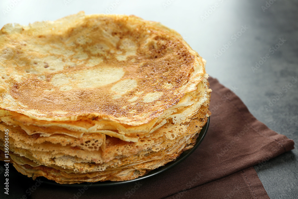 Stack of delicious pancakes on grey table