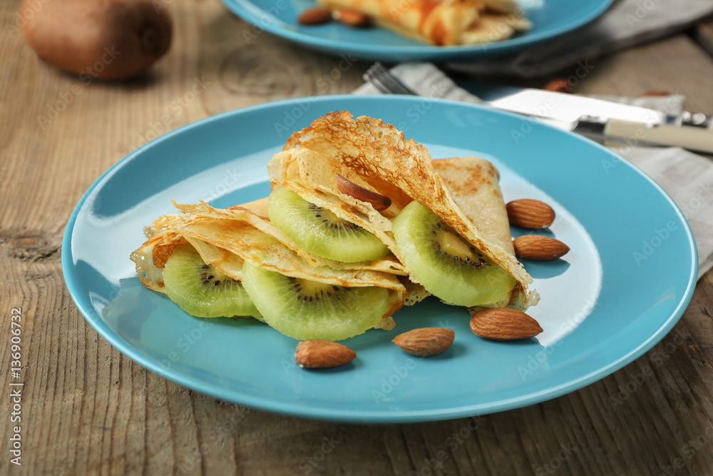 Blue plate with delicious pancakes on wooden table Blue plate with delicious pancakes on wooden table
