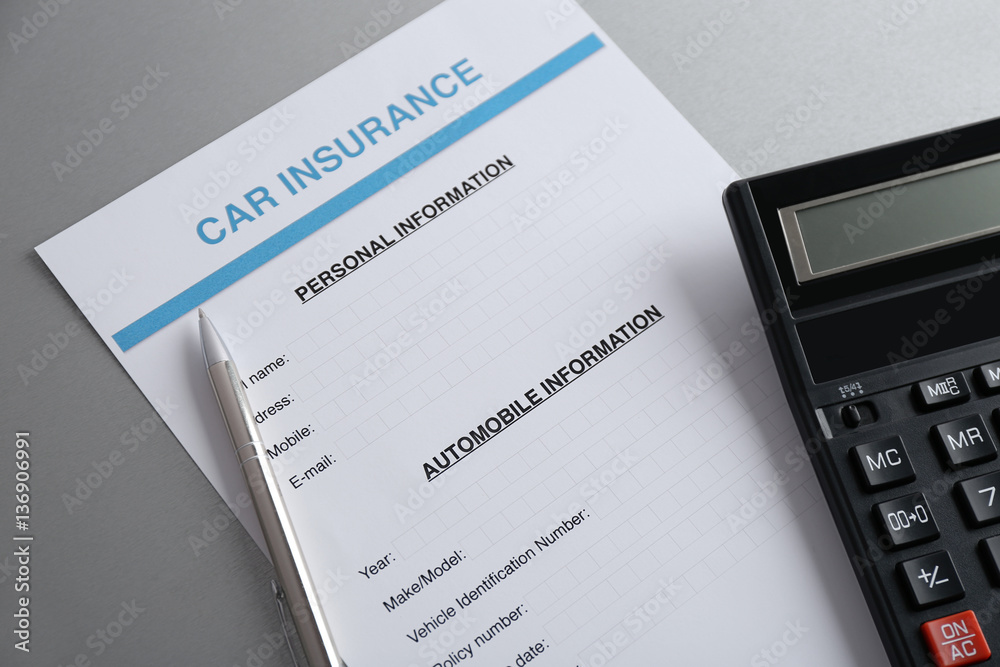 Car insurance form, calculator and pen on table Car insurance form, calculator and pen on table