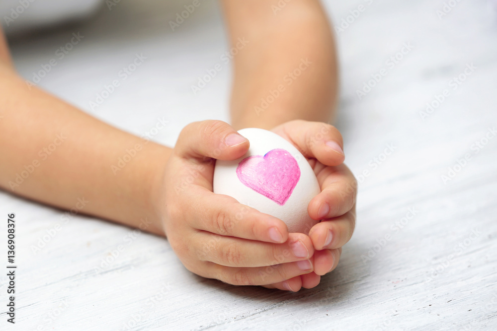 Hands of cute little child holding Easter egg, closeup Hands of cute little child holding Easter egg, closeup
