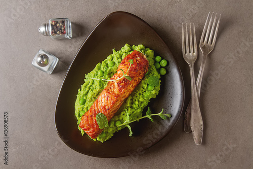 Grilled salmon pea puree decorated with mint on a brown plate. G