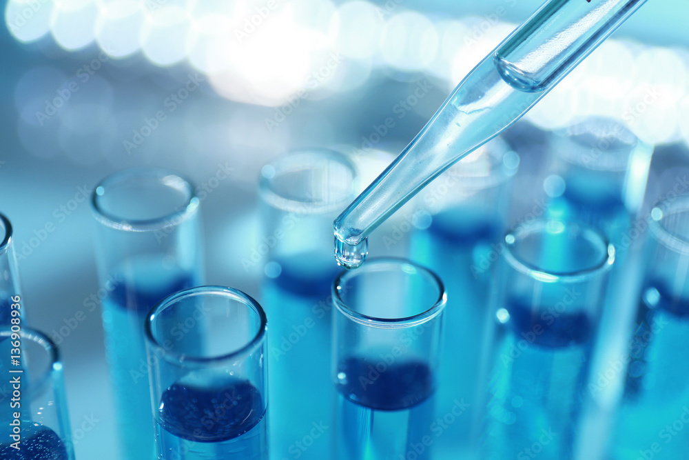 Pipette dropping sample into test tube, closeup Pipette dropping sample into test tube, closeup