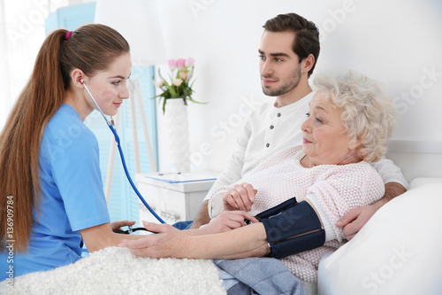 Nurse measuring woman's blo...