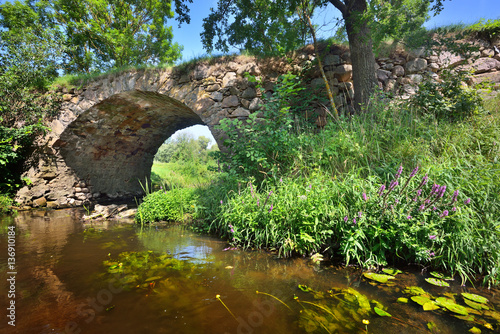 Small medieval bridge across the river Vilce in Latvia. photo