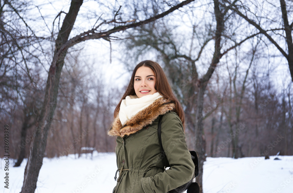 Portrait of young beautiful woman in winter park