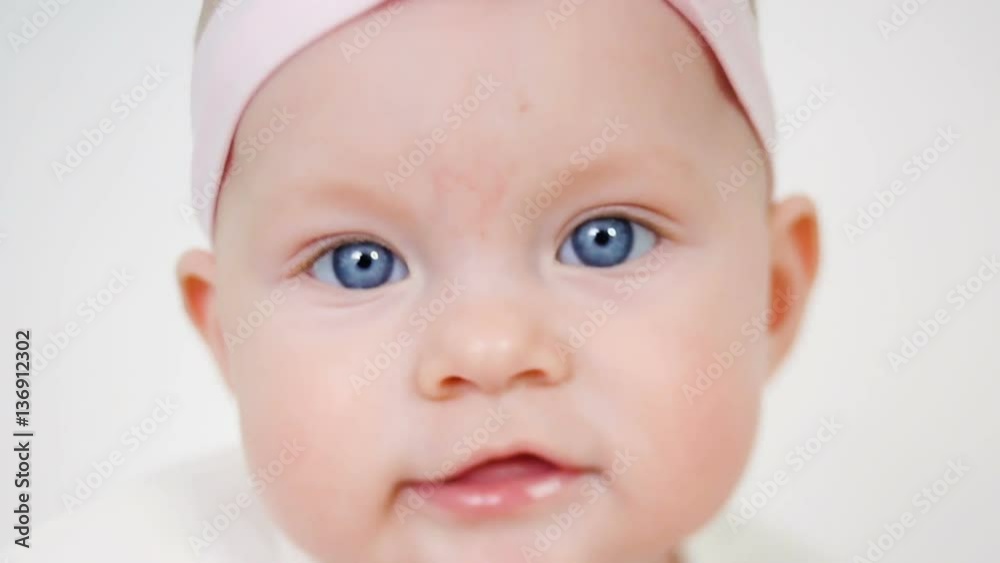baby girl in white dress and headband sitting on the wooden floor baby girl in white dress and headband sitting on the wooden floor