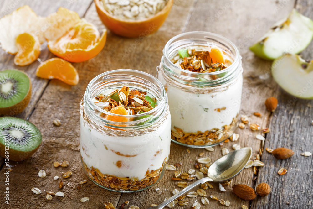 Healthy homemade granola with yogurt and fruits in a rustic jar. Traditional American food on a table. Classic snack. Top view.