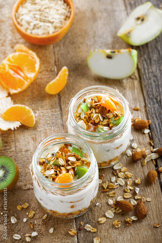 Granola with yogurt and fruits in a rustic jar. Delicious healthy American food for breakfast. Traditional US snack. Top view shot. Granola with yogurt and fruits in a rustic jar. Delicious healthy American food for breakfast. Traditional US snack. Top view shot.