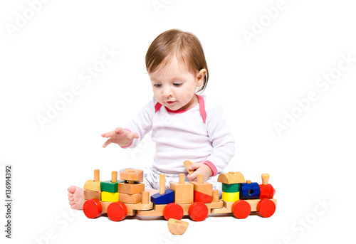 Beautiful little girl playing wooden train