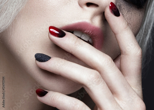Beautiful blond girl with dark smokey makeup and art manicure design nails. beauty face. Close up. Photos shot in studio